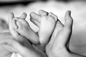 mothers-hands-holding-baby-feet-black-and-white