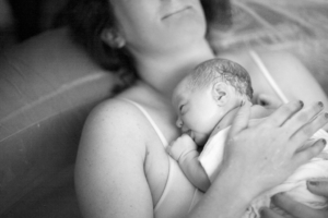 Newborn baby lying on woman's chest