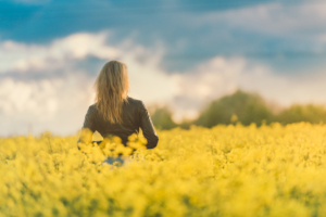 woman-standing-in-field-of-yellow-flowers