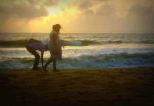 pregnant-woman-and-partner-walking-on-the-beach