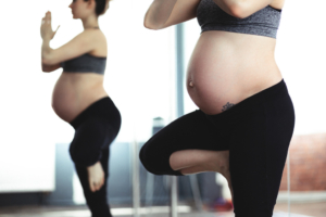 pregnant-woman-doing-yoga-tree-pose-with-mirror-reflection