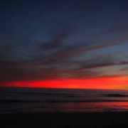 pregnant-woman-standing-on-the-beach-with-sunset-behind-her