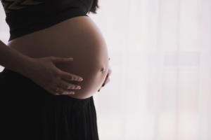 close-up-of-pregnant-woman-holding-her-belly