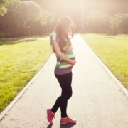 pregnant-girl-holding-her-belly-walking-on-path