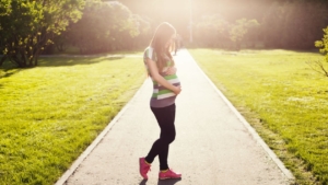 pregnant-girl-holding-her-belly-walking-on-path