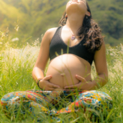 pregnant-woman-sitting-cross-legged-in-a-field