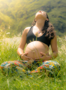 pregnant-woman-sitting-cross-legged-in-a-field