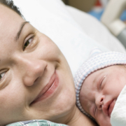 Smiling woman holding newborn baby