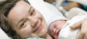 Smiling woman holding newborn baby