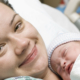 Smiling woman holding newborn baby